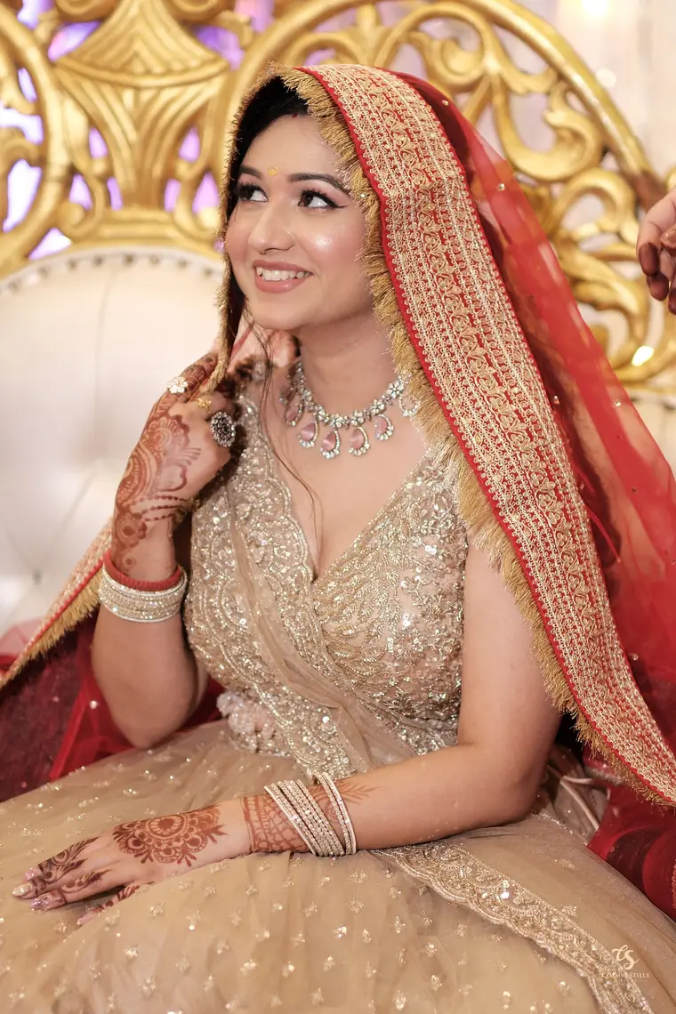 Nishtha smiling beneath her red embroidered dupatta